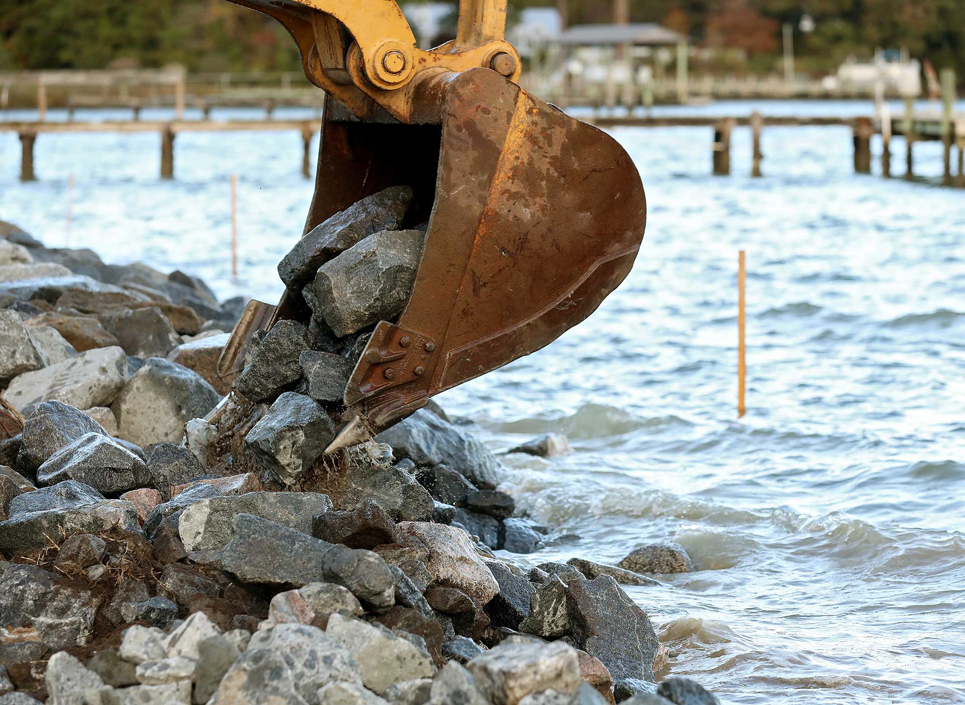 Granite rocks are carefully placed in the Ware River to create a living shoreline to prevent erosion and protect property