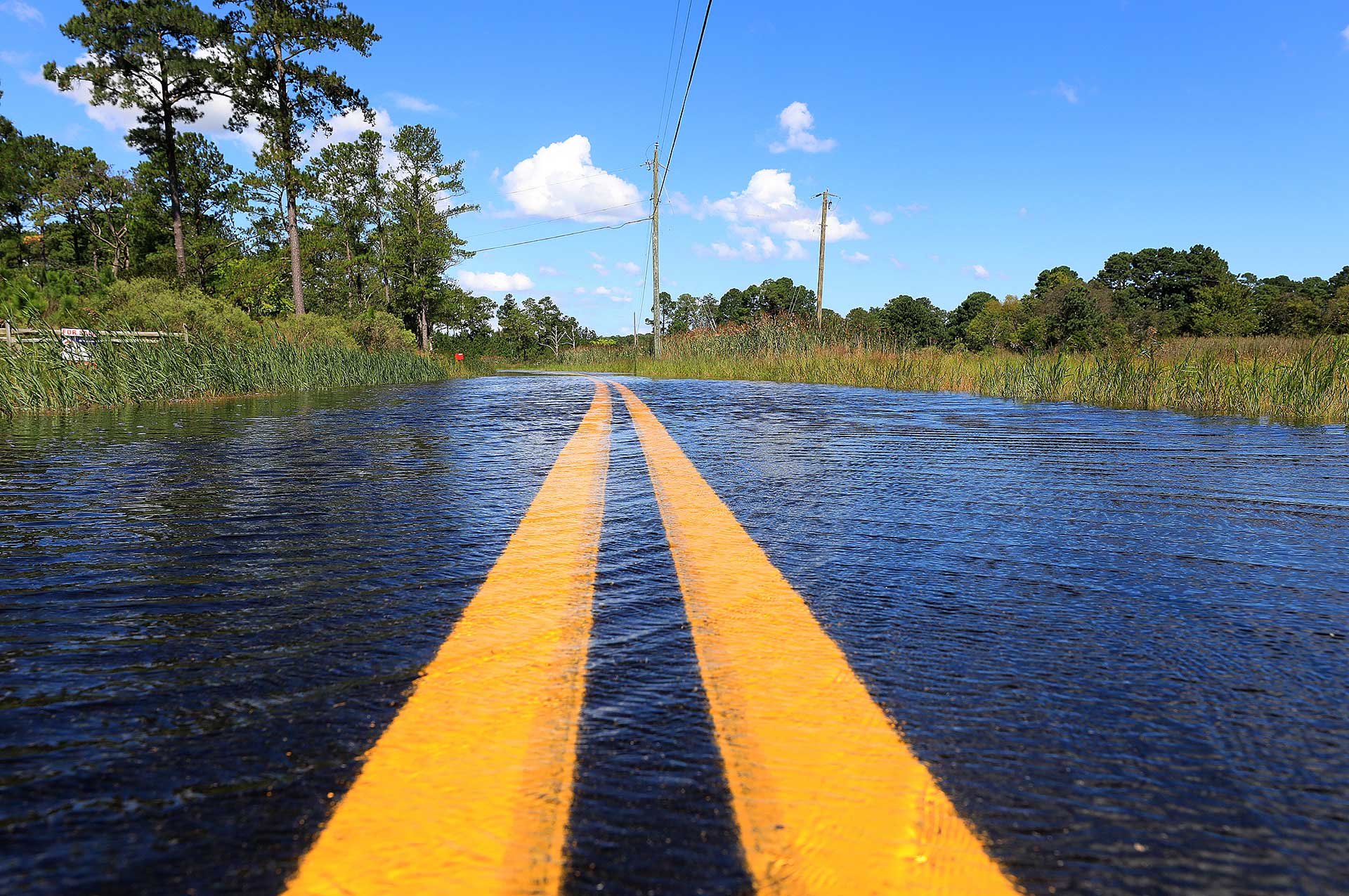 Tidal flooding pushes water across Jenkins Neck Road in Guinea 