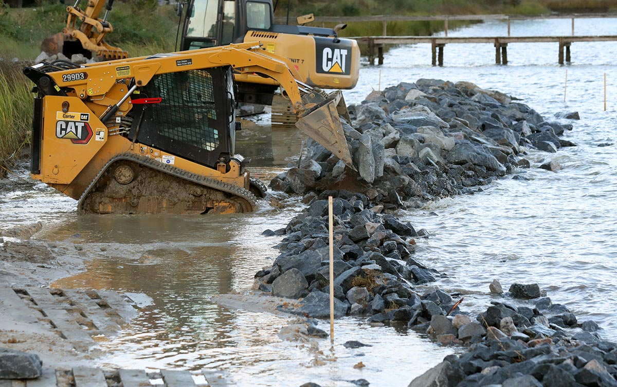 Granite rocks are carefully placed in the Ware River to create a living shoreline to prevent erosion and protect property