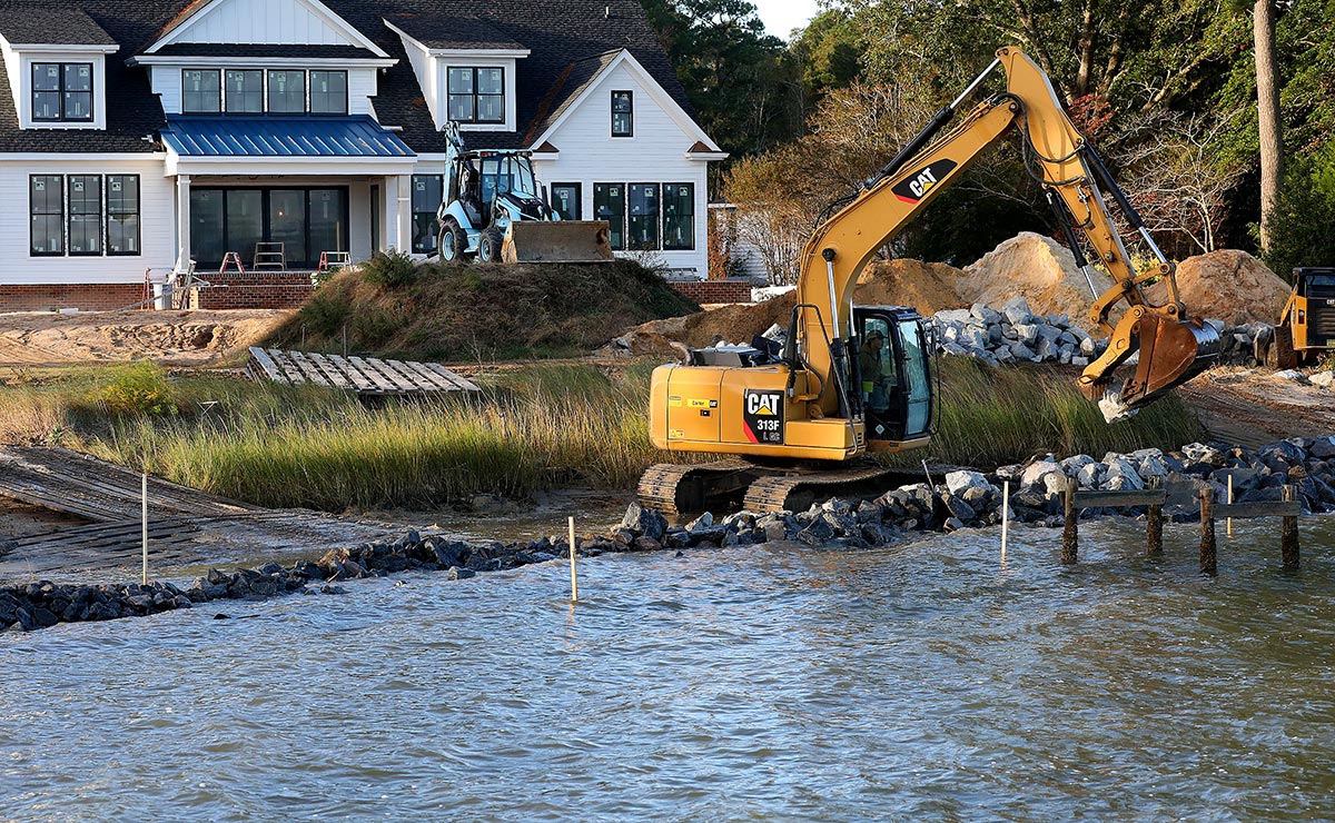 Granite rocks are carefully placed in the Ware River to create a living shoreline to prevent erosion and protect property 