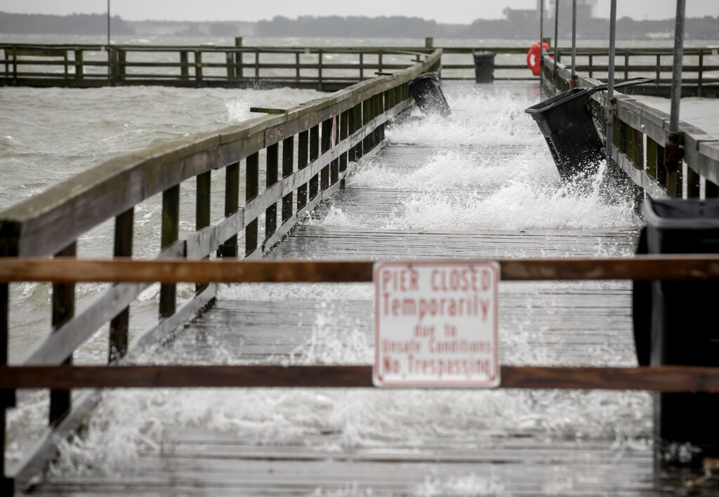 Storm surge floods a wooden pier, highlighting the threat of tidal flooding in coastal Virginia.